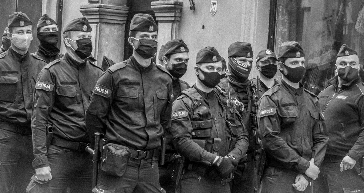Row of masked police officers standing shoulder to shoulder